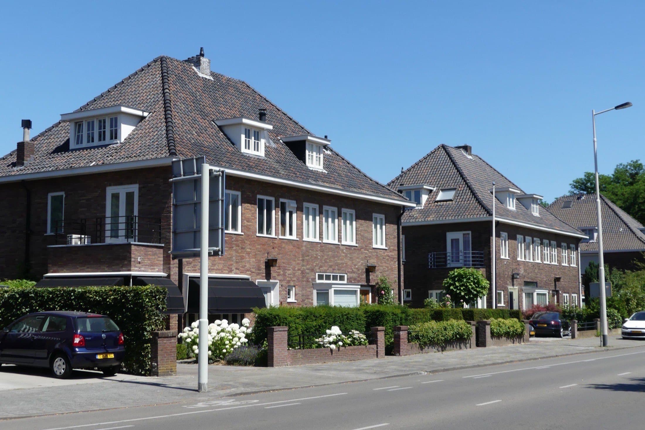 Twee-onder-een-kapwoningen in jaren-dertigstijl met hoge pannendaken en witte kozijnen aan de Julianalaan in de Bredase wijk Boeimeer.