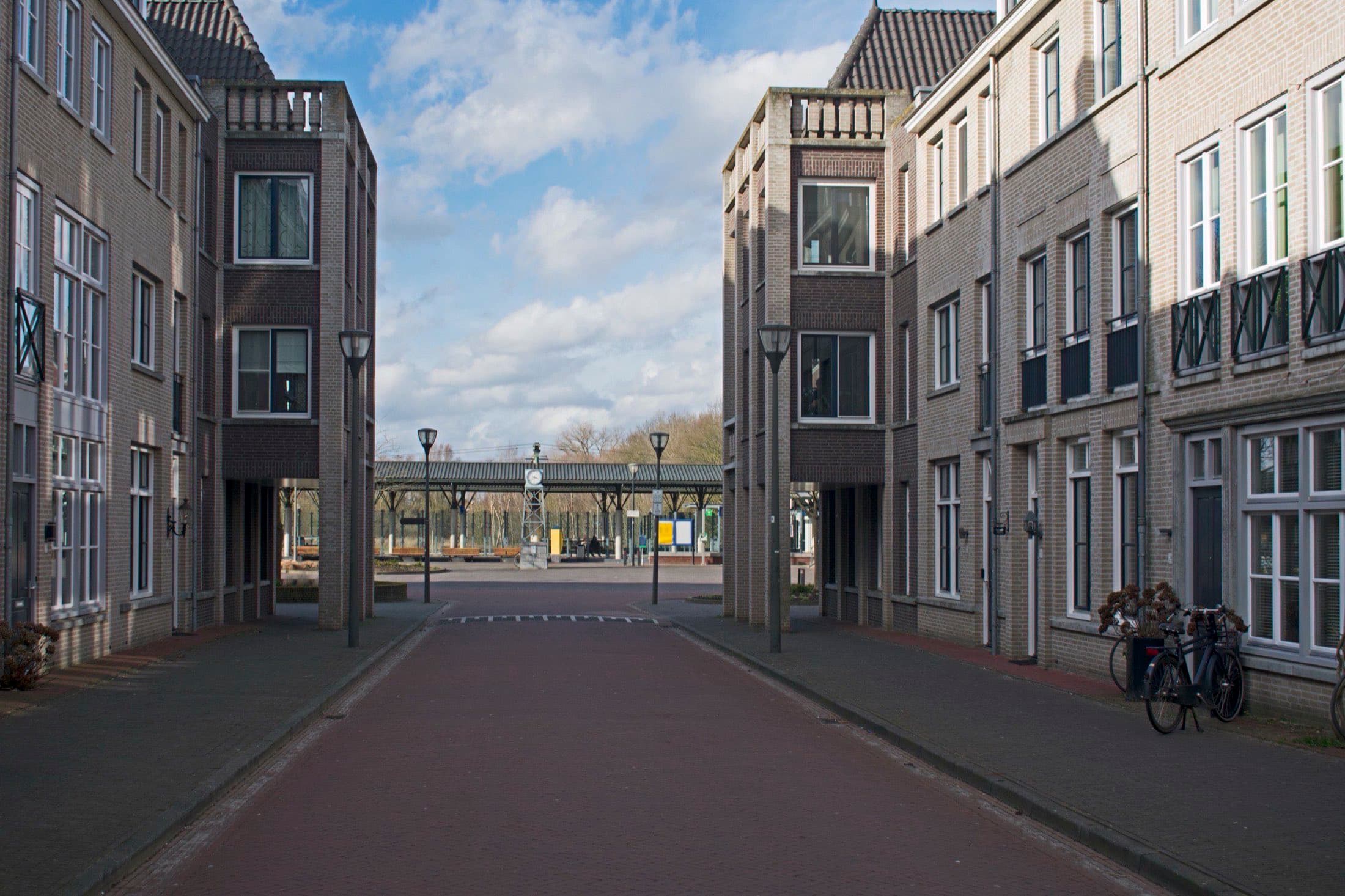 Straat met nieuwbouwwoningen in traditionele stijl in de wijk Brandevoort in Helmond, met aan het eind het station.