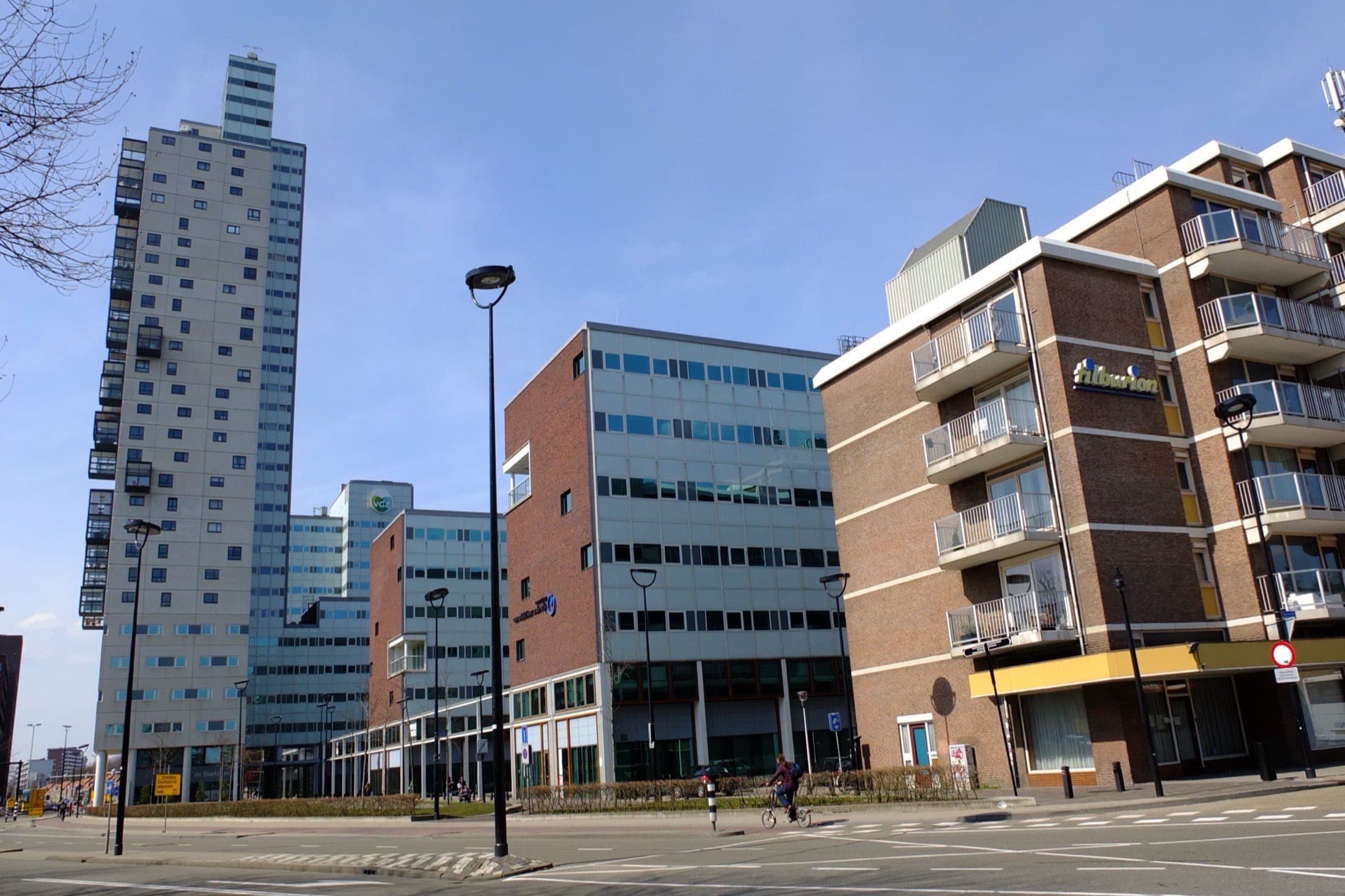Kantoorgebouwen en de woontoren Westpoint aan de Spoorlaan in Tilburg, met op de voorgrond een appartementengebouw met balkons.